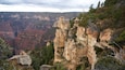 Een canyon met opvallende rotsformaties en schaarse begroeiing.