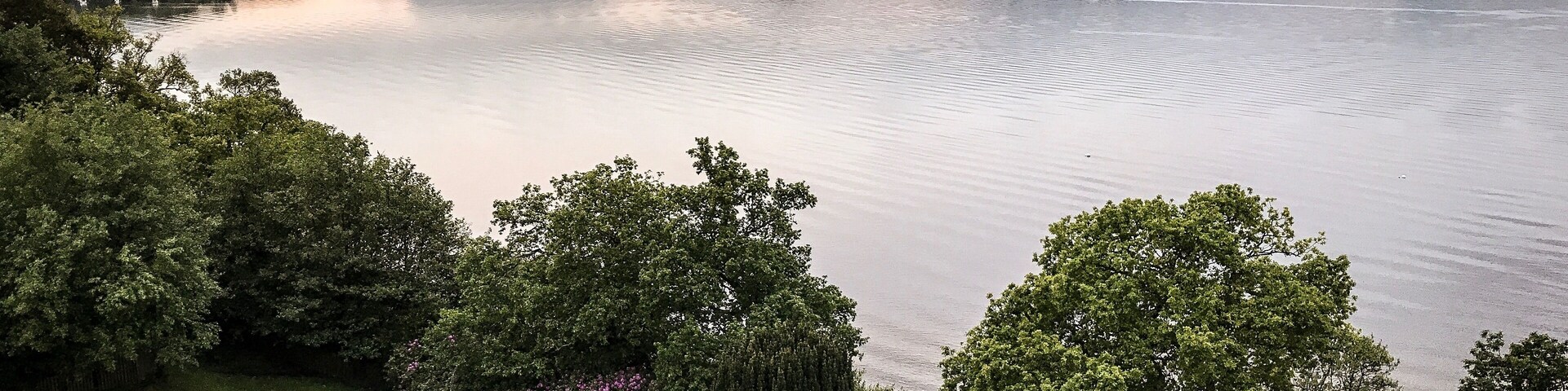 A lake surrounded by mountains and lush greenery.