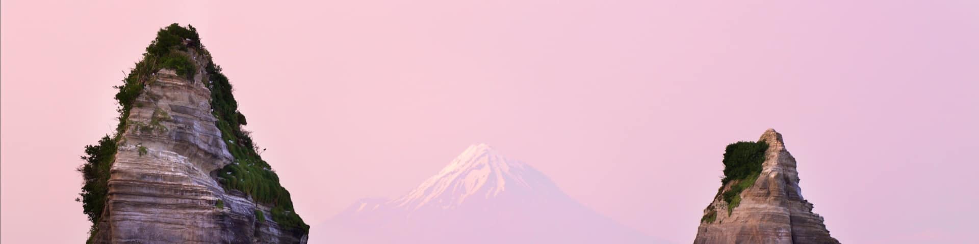 Tongaporutu featuring a sunset, mountains and a bay or harbor