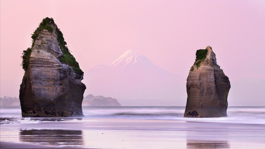 Tongaporutu which includes a sunset, a bay or harbour and mountains