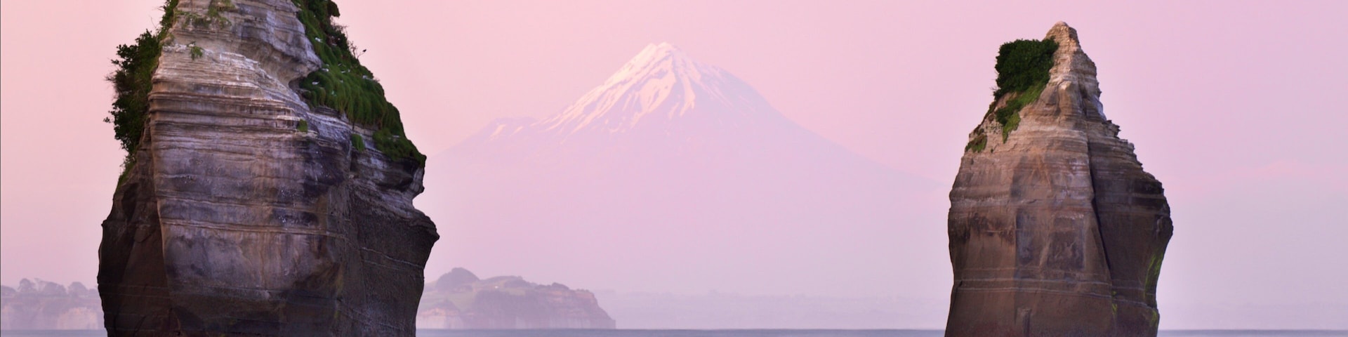 Tongaporutu ofreciendo un atardecer, costa escarpada y montañas