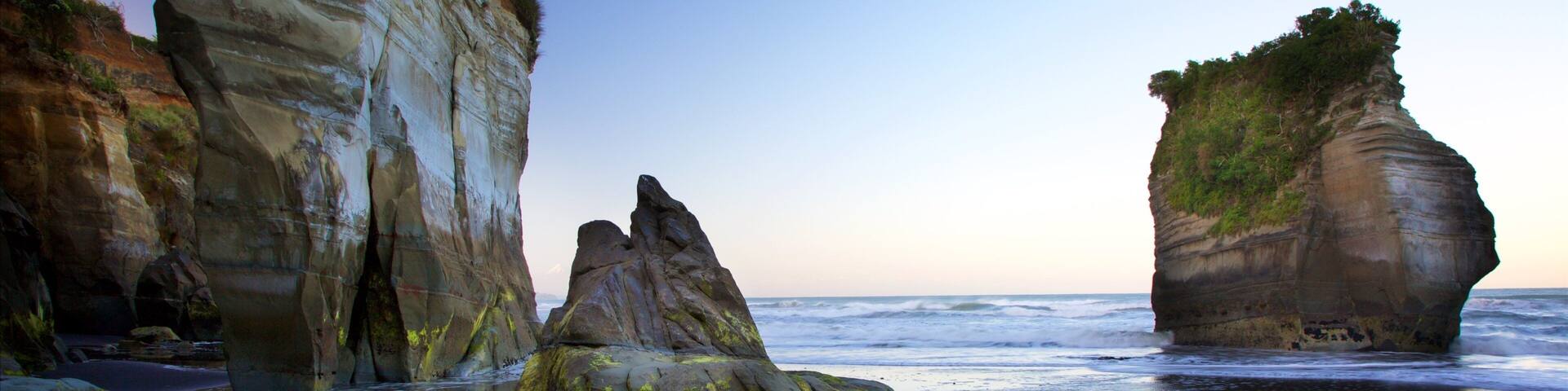 Tongaporutu featuring rocky coastline, a beach and a bay or harbor