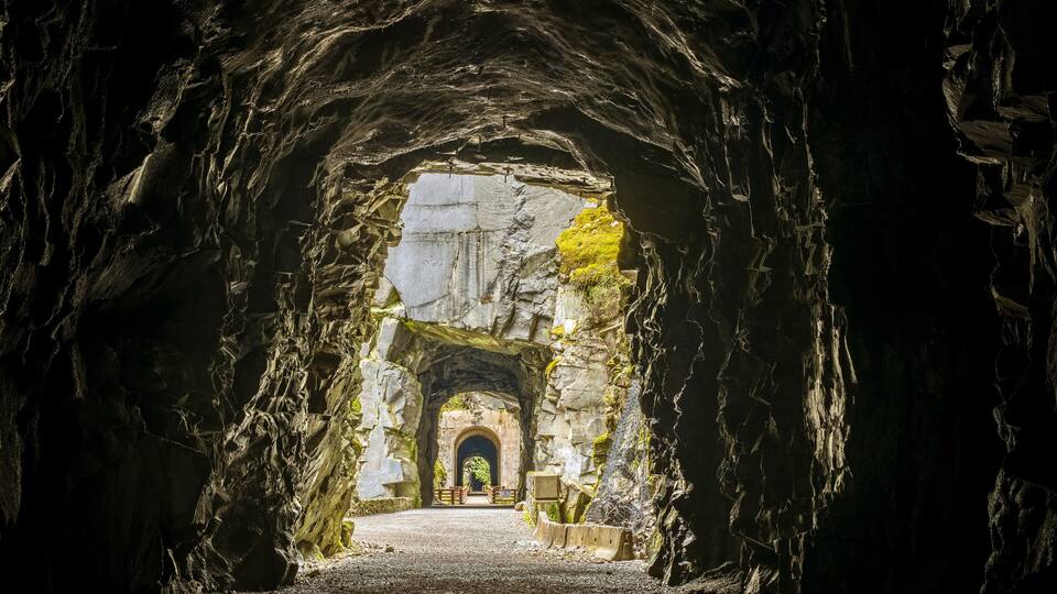 A cave entrance with a stone archway leading to a pathway.