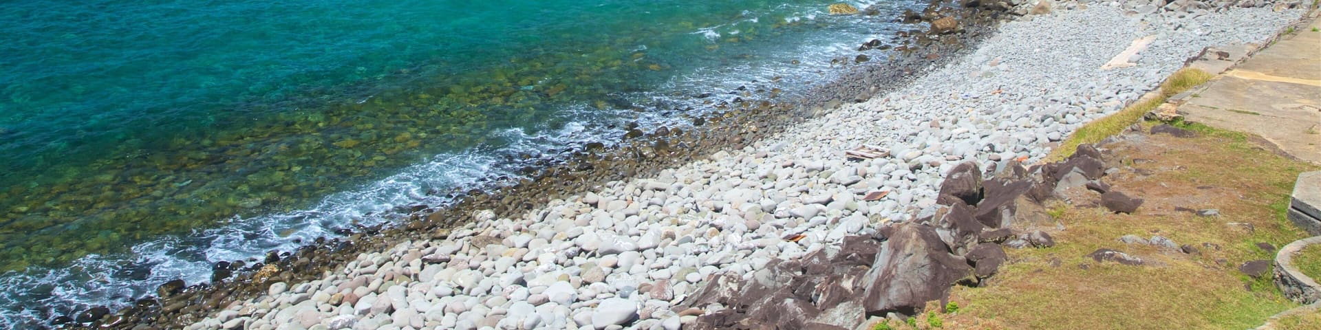 Norfolk Island which includes a pebble beach, rugged coastline and general coastal views