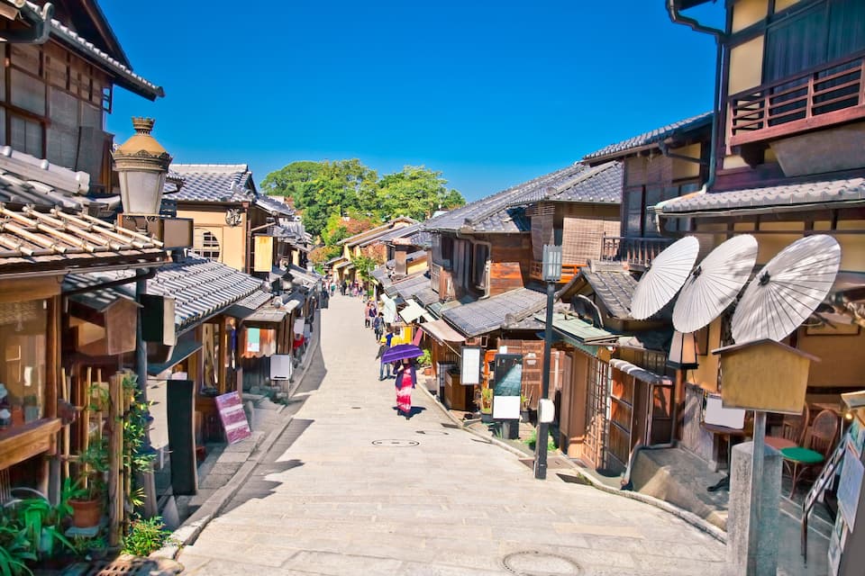 A narrow street lined with traditional buildings, some with satellite dishes.