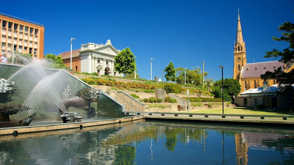 A fountain, a church, and a building with a clock tower.