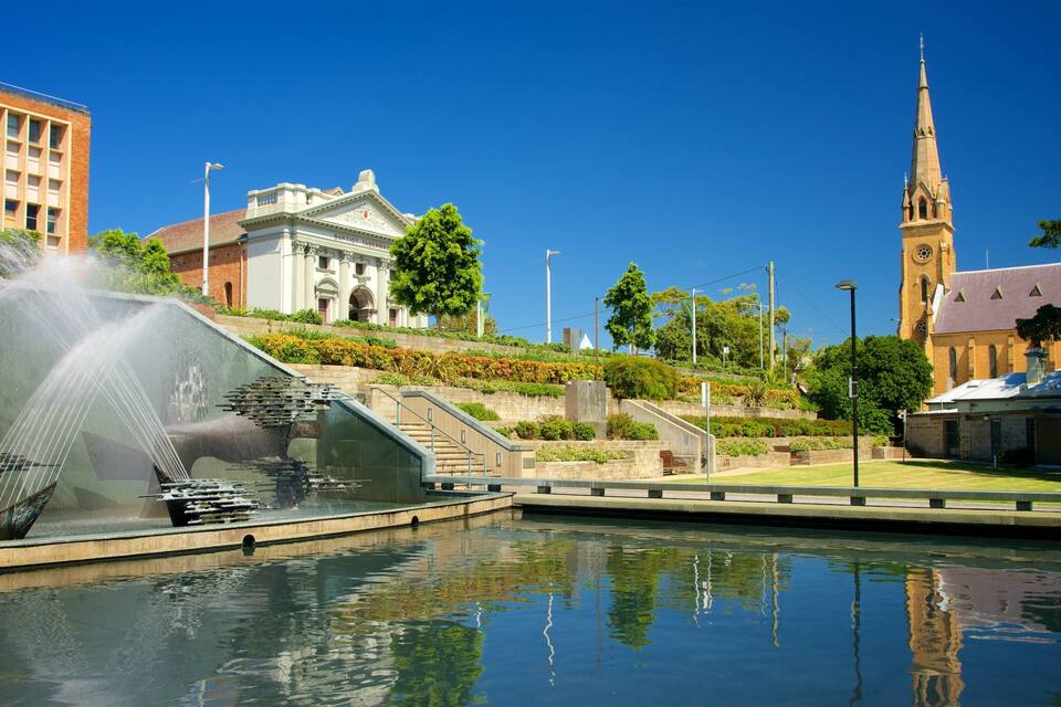 A fountain, a church, and a building with a clock tower.