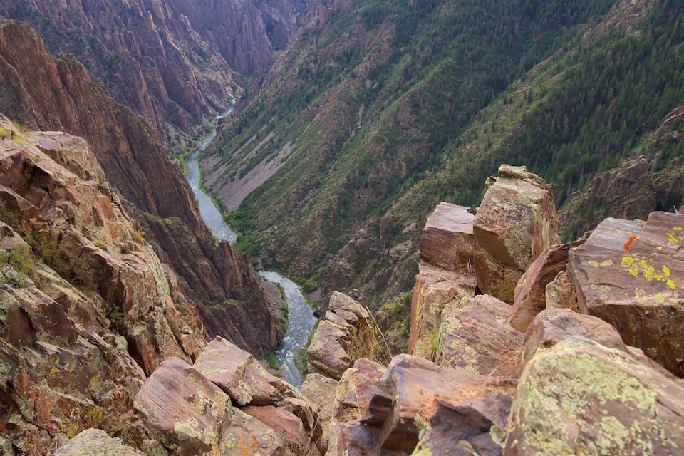 A canyon with a river flowing through it, surrounded by rocky cliffs and sparse vegetation.