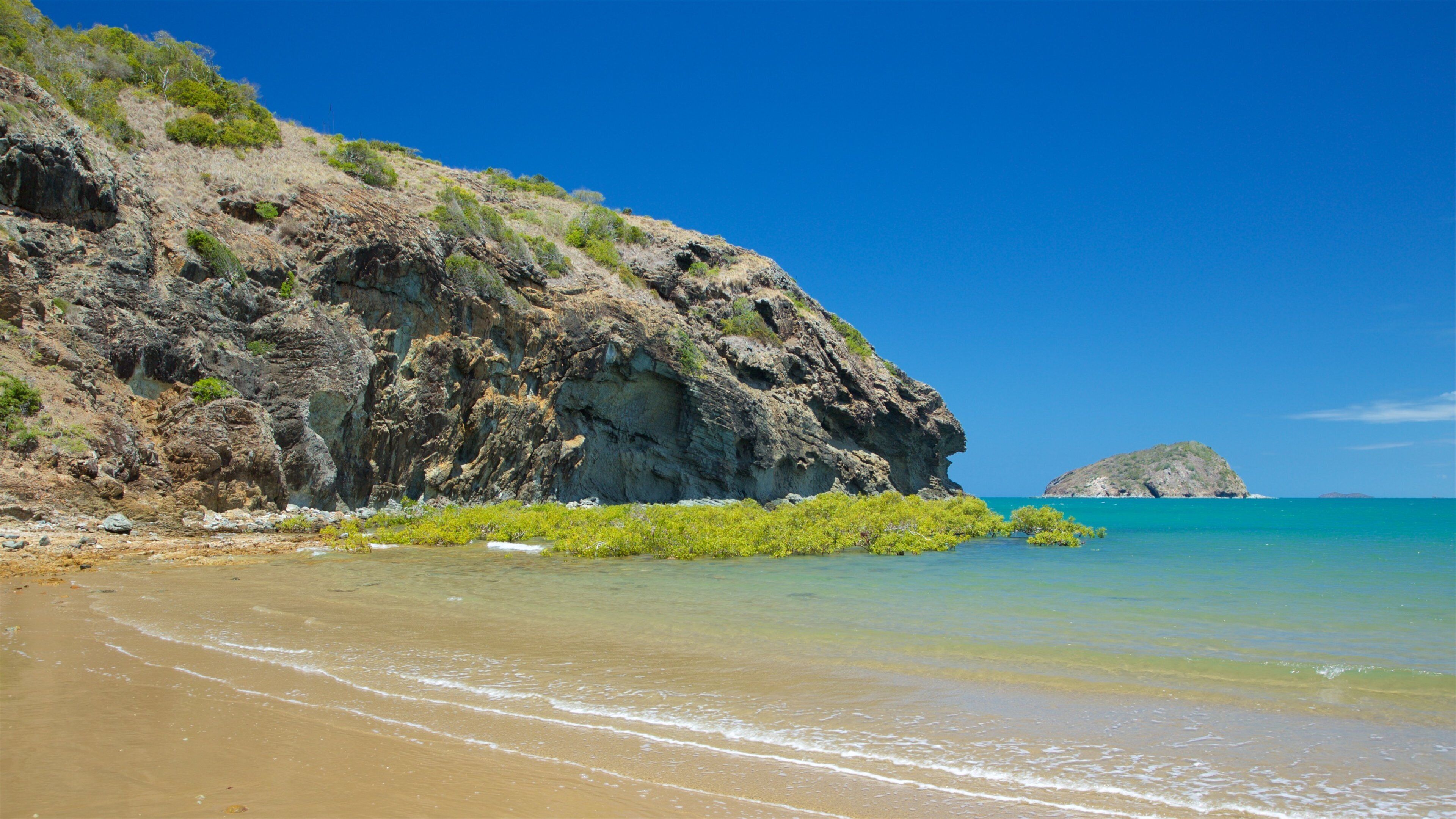 Rosslyn Bay featuring rocky coastline, general coastal views and a beach