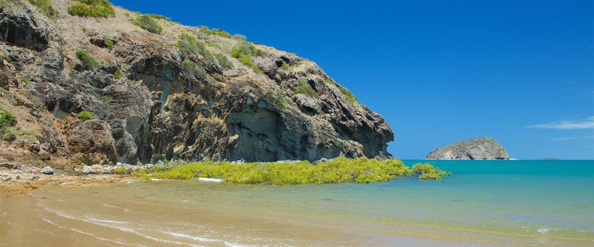 Rosslyn Bay featuring rocky coastline, general coastal views and a beach