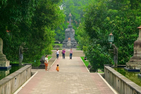 Mendut Buddhist Monastery which includes a park and heritage elements as well as a small group of people