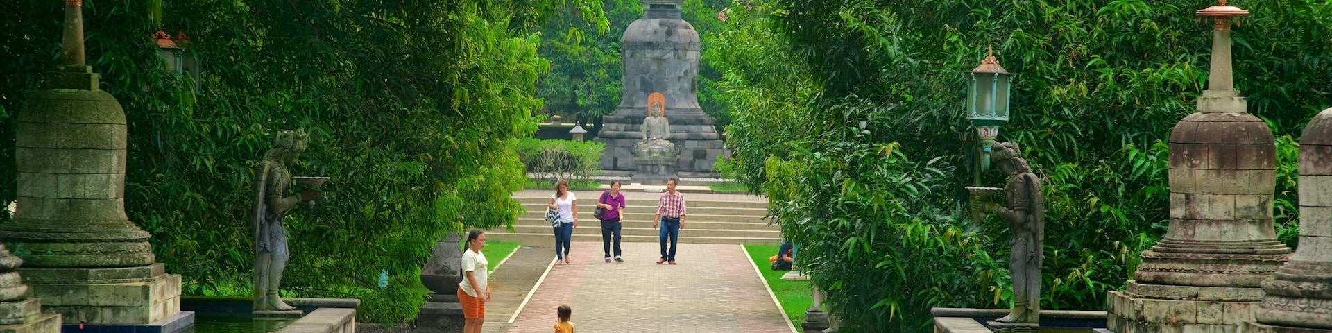 Mendut Buddhist Monastery which includes a park and heritage elements as well as a small group of people