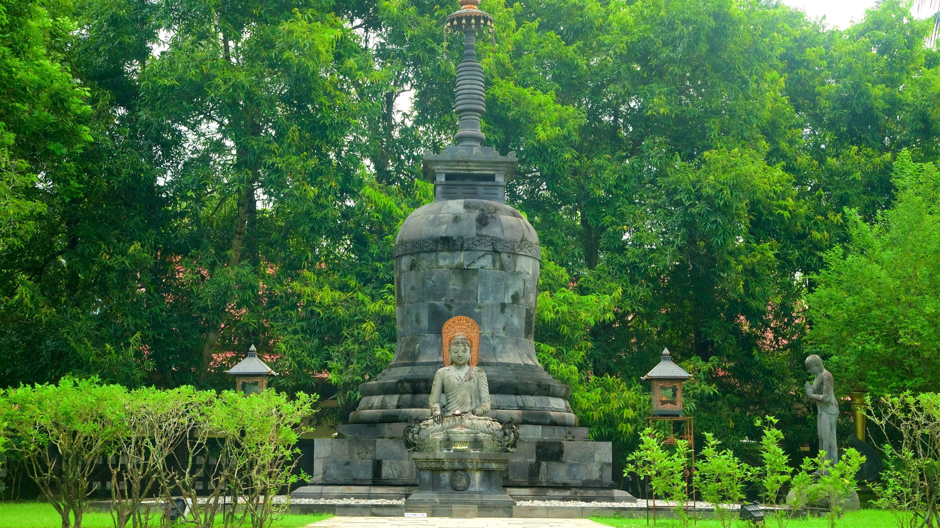 Mendut Buddhist Monastery featuring a fountain and a garden