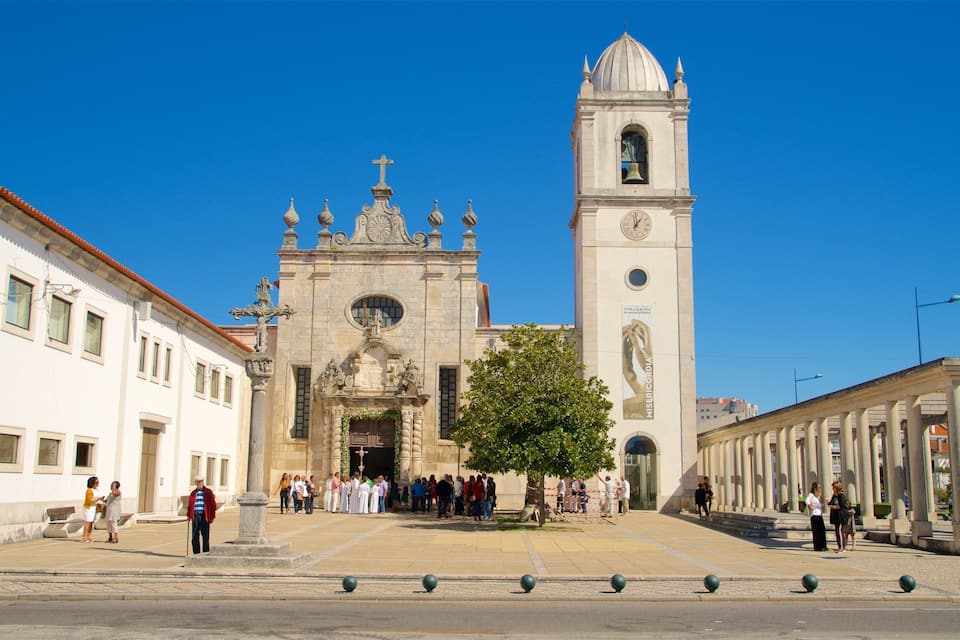 A historic church with a bell tower and a crowd of people in front.