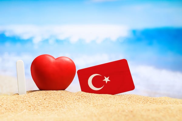 I love Turkey. Flag of Turkey on the beach with a red heart. vacation and travel concept.