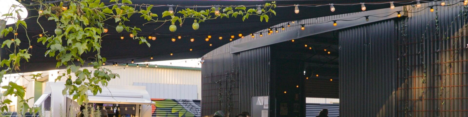 All Inn Brewing Co. showing outdoor eating as well as a small group of people