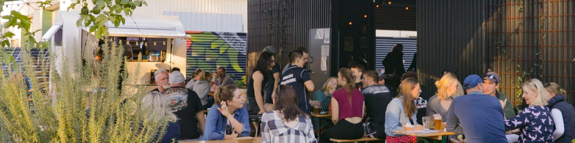 All Inn Brewing Co. showing outdoor eating as well as a small group of people