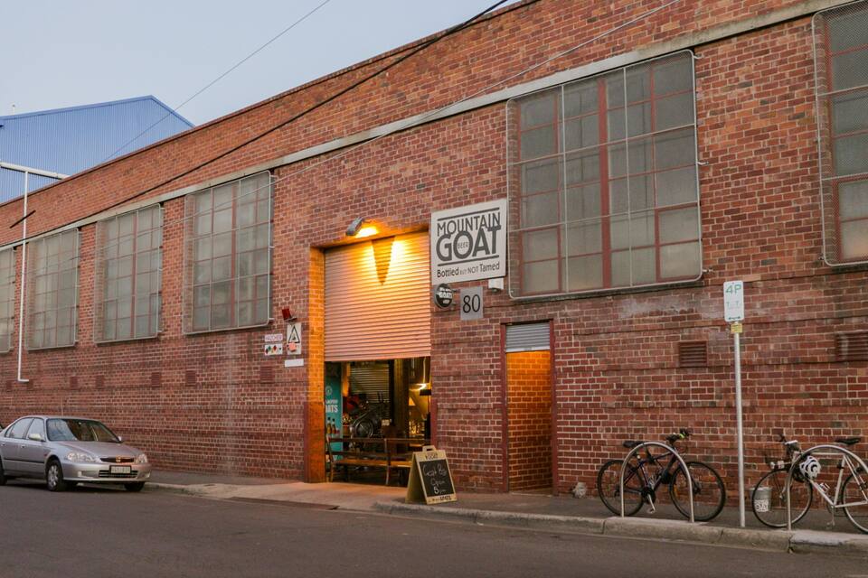 Un edificio in mattoni con ampie finestre e un cartello che indica Mountain Goat Brewery.