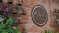 The Public Brewery featuring signage and flowers