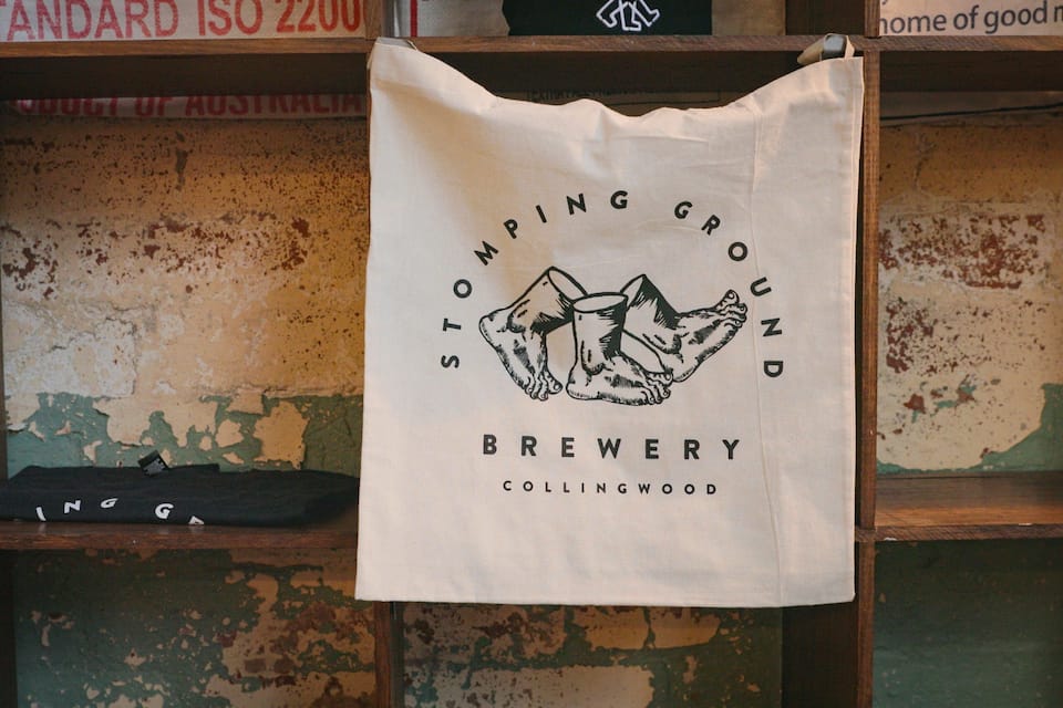 A cloth hanging on a wooden shelf with a logo that reads "Stomping Ground Brewery Collingwood".