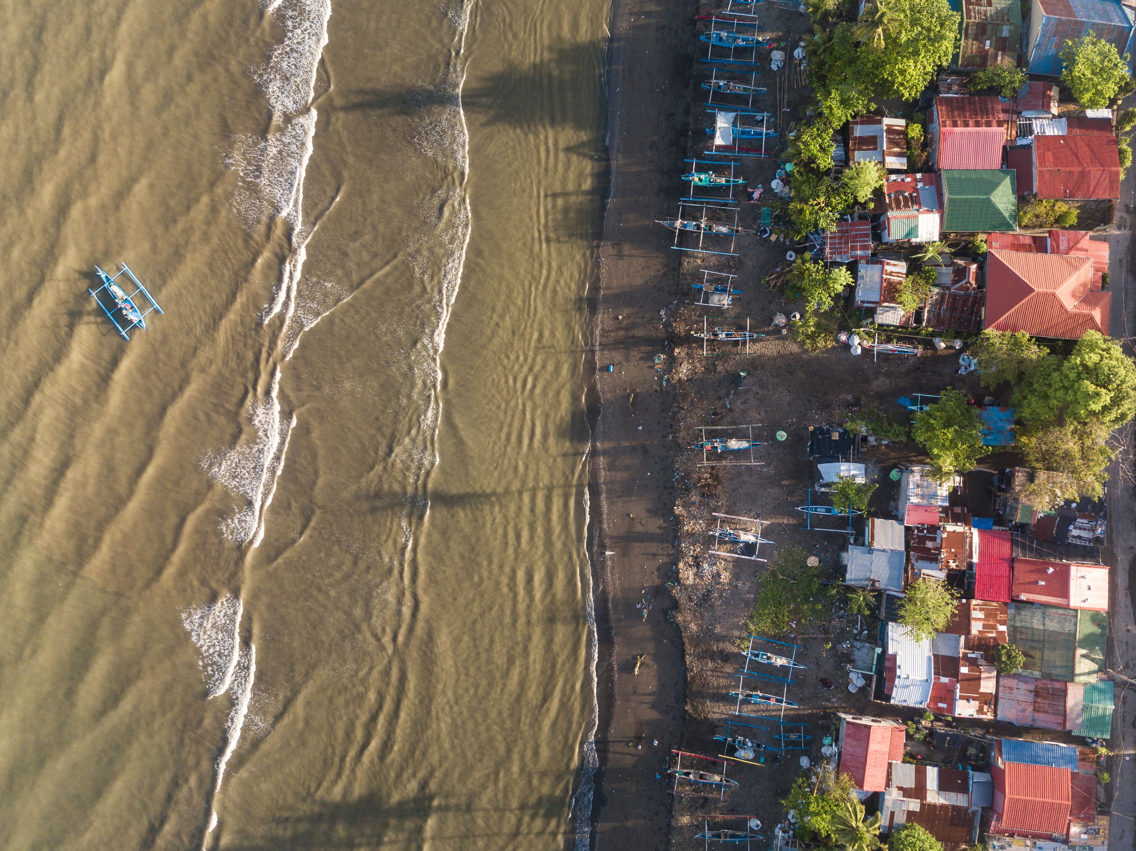 Top aerial view of a beach and fishing village in Naic, Cavite, Philippines.