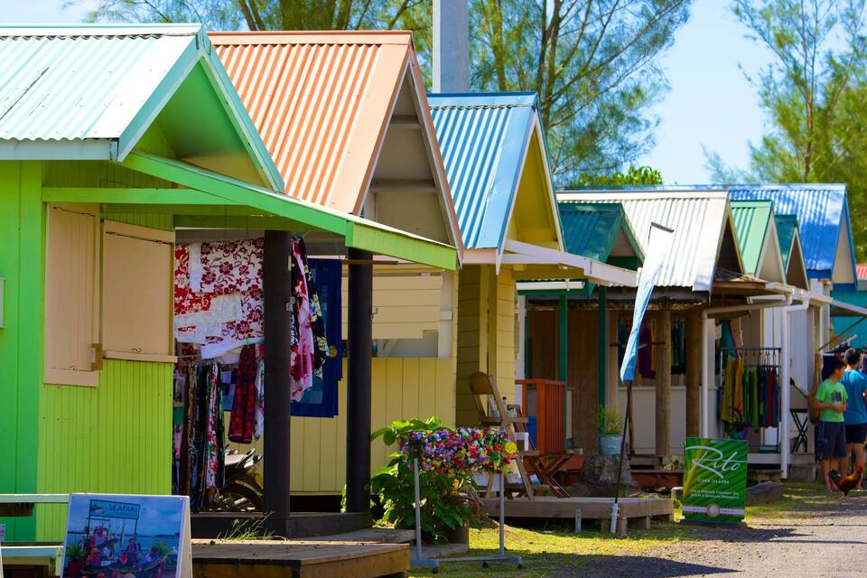 Cabañas de playa coloridas con un letrero que dice 'Rito Coconuts'.