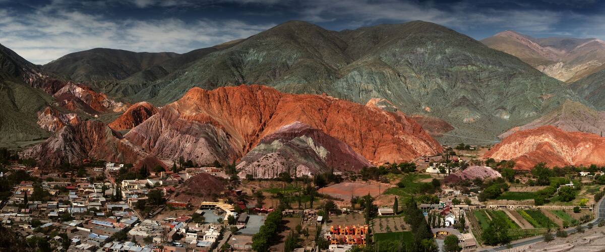 A town nestled in a valley with mountains in the background.