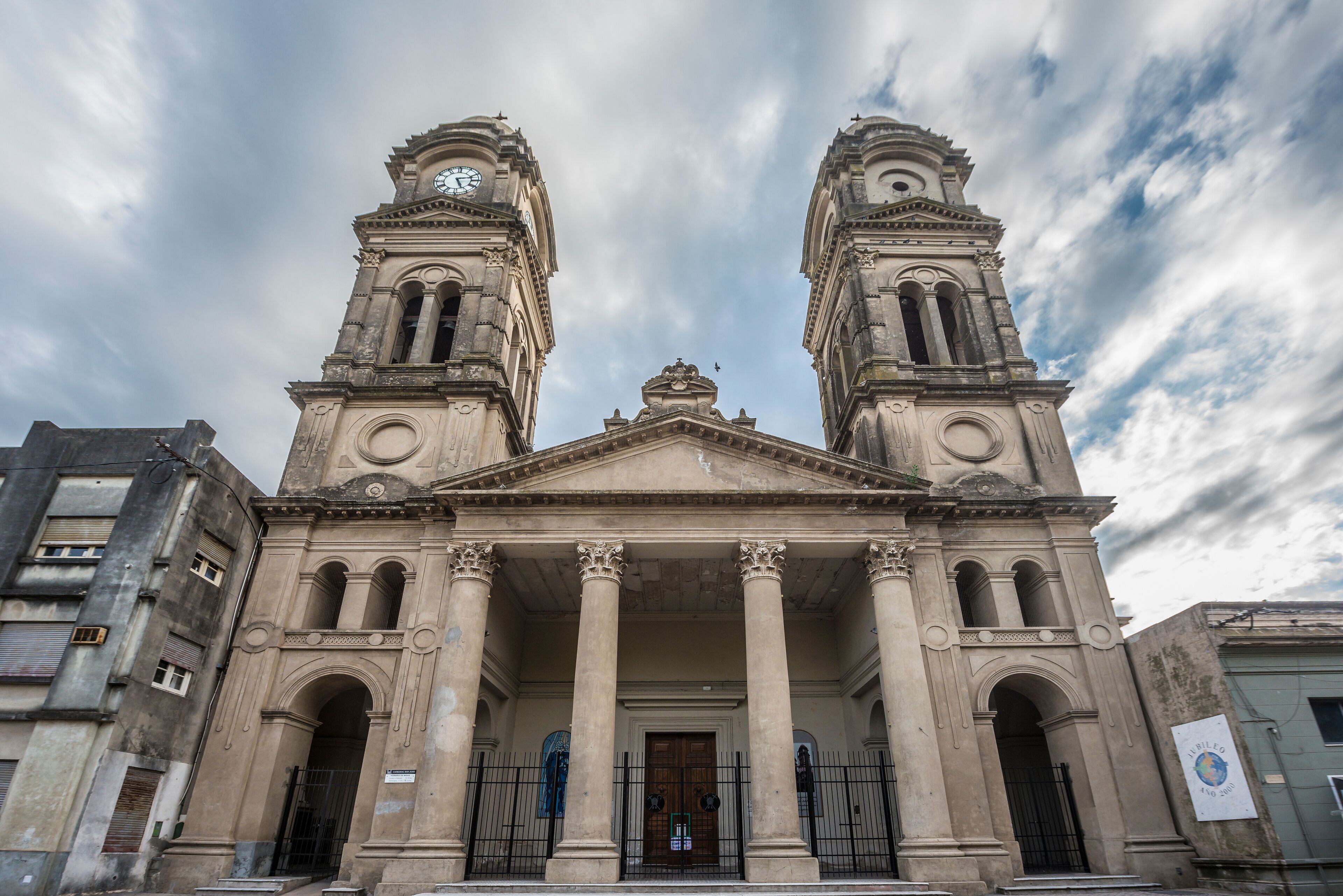 A historic building with two clock towers and a central entrance with columns.