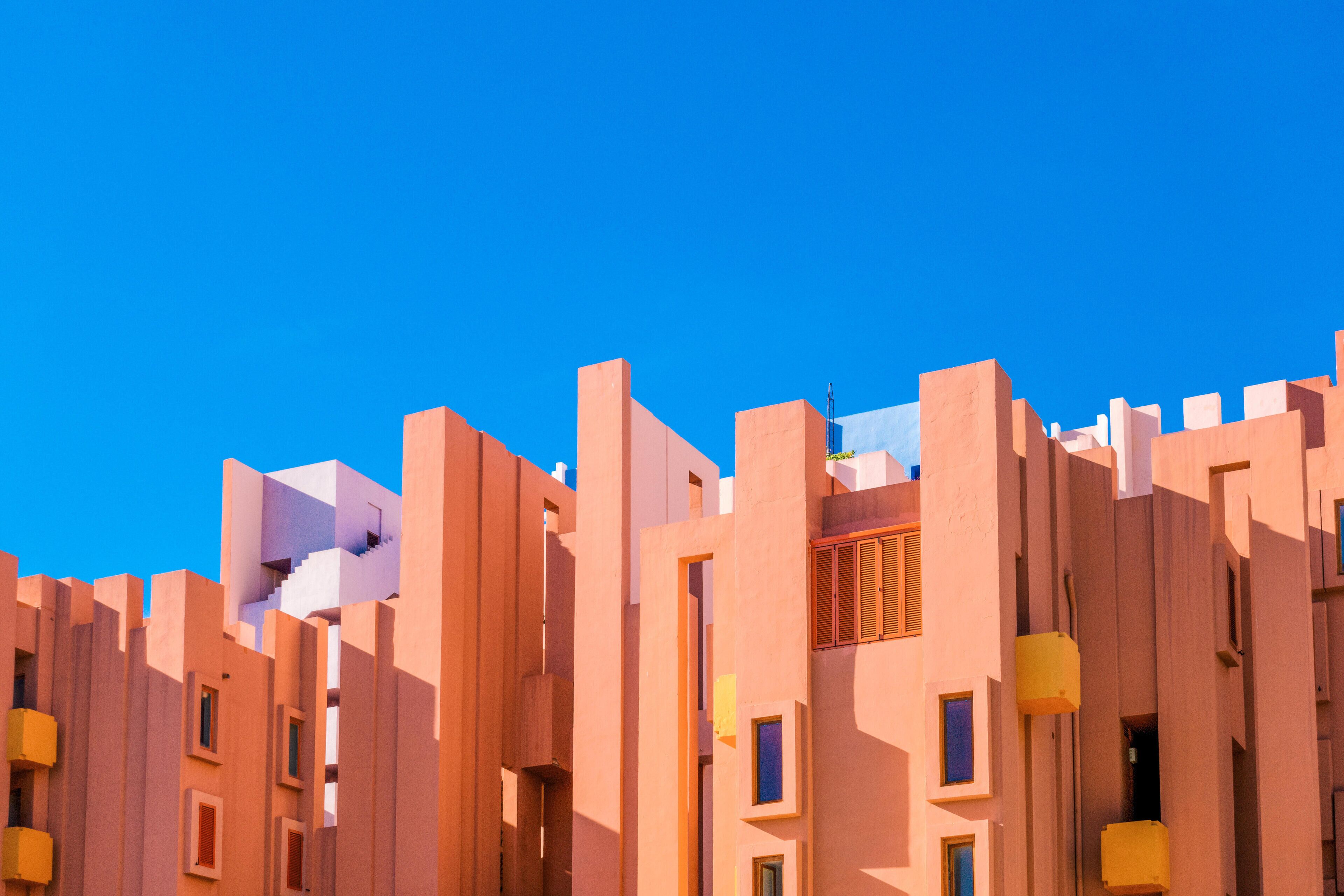 A cluster of modern buildings with a clear blue sky in the background.