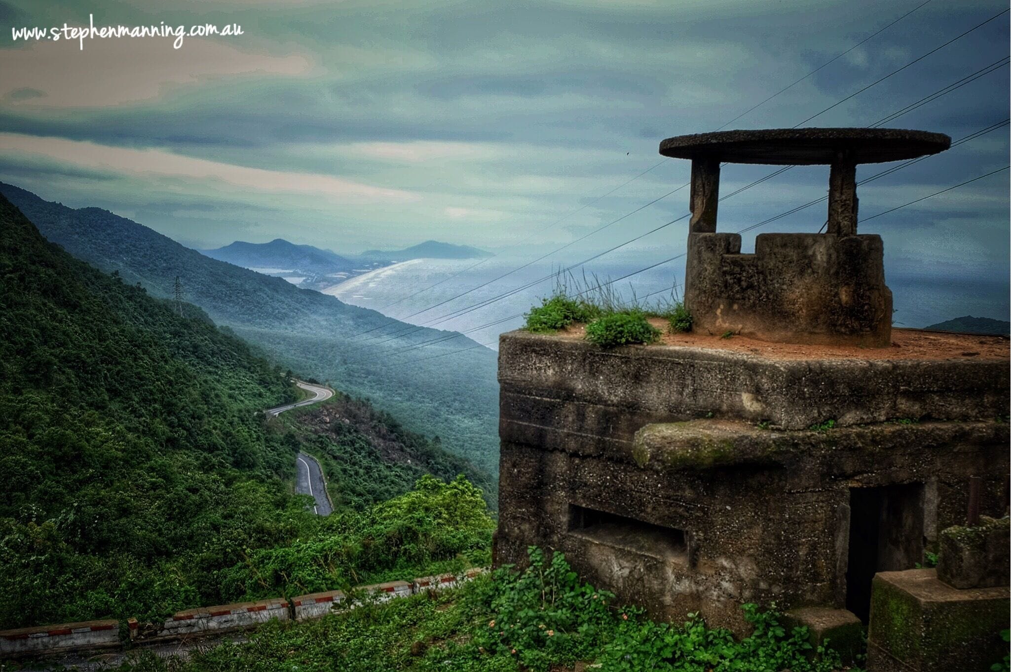 Hải Vân Pass (translated means 'Ocean Cloud Pass') is a high mountain pass approximately 20 klms long between Huế and Đà Nẵng in central Vietnam. Throughout history it has been a major strategic physical barrier between the north and the central regions of Vietnam.

With such an amazing vantage point I was not surprised to see the concrete guard box at the top. An obvious military relic left over from the many conflicts.

I was surprised however when a small Vietnamese fellow appear out of nowhere and demanded $1 US to climb his ladder to be able to stand on the top and take a photo.

I found it quite a surreal experience that I am still trying to wrap my head around. #Mountains 

