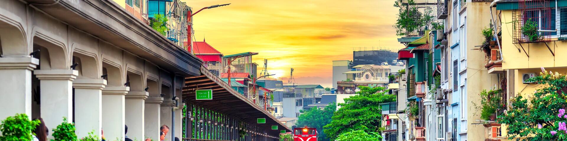 Train running on ancient railway at Long Bien bridge station in Hanoi, Vietnam with market community