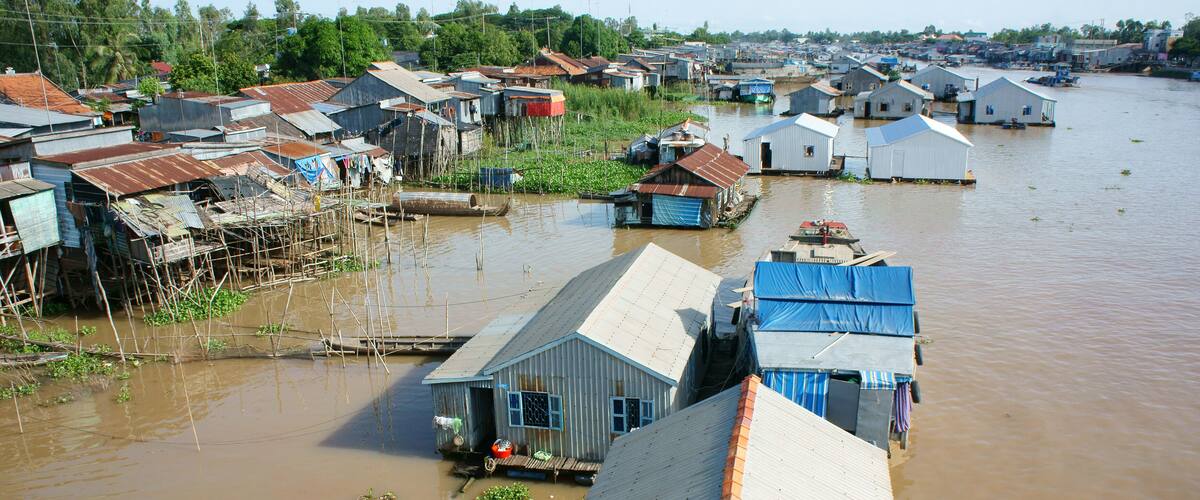 A waterlogged village with floating houses and boats.