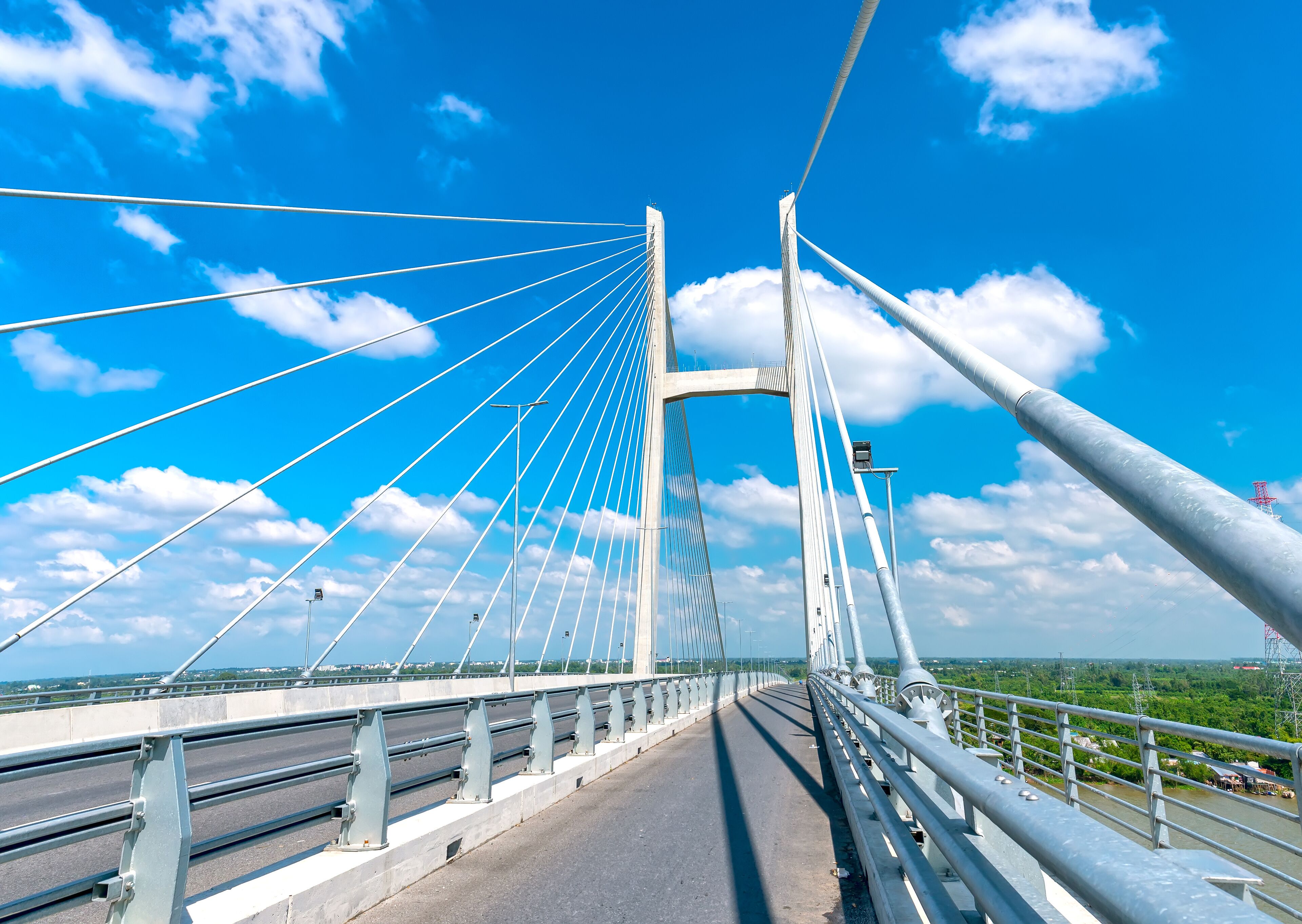 A cable-stayed bridge with multiple cables, a clear sky, and a river below.