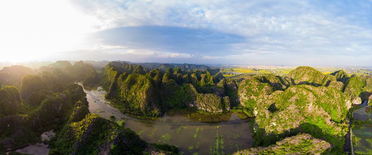 A river winding through a lush, green valley with dense forested hills.