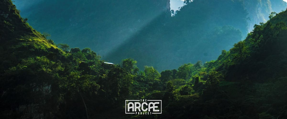 A mountainous landscape with dense green vegetation and a clear sky.
