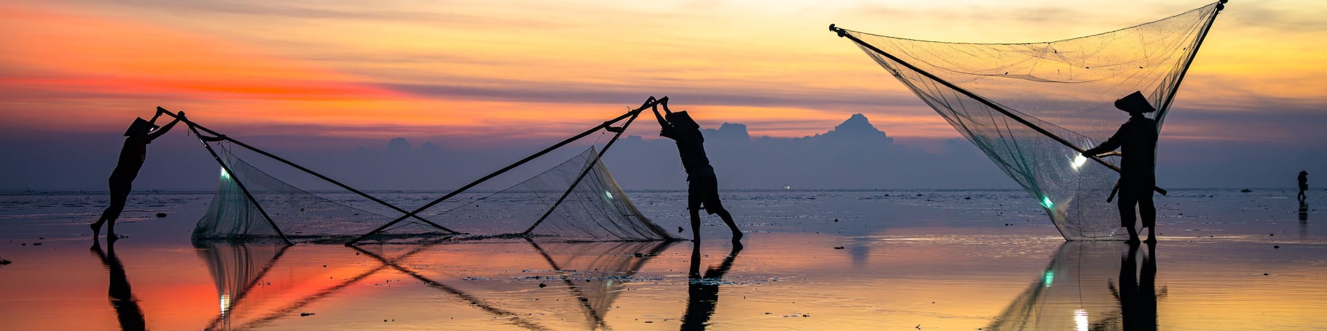 Fishermen at Quang Lang beach, Thai Binh, casting nets at sunrise. A glimpse into coastal life and daily livelihood. Photo taken on July 27, 2025.