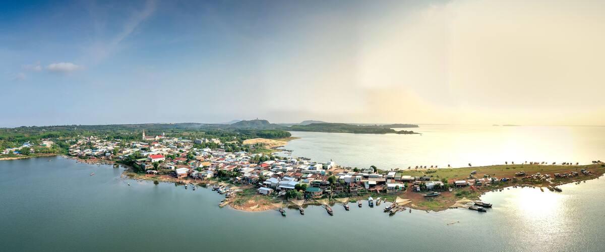 An aerial view of a coastal town with houses, boats, and a river.