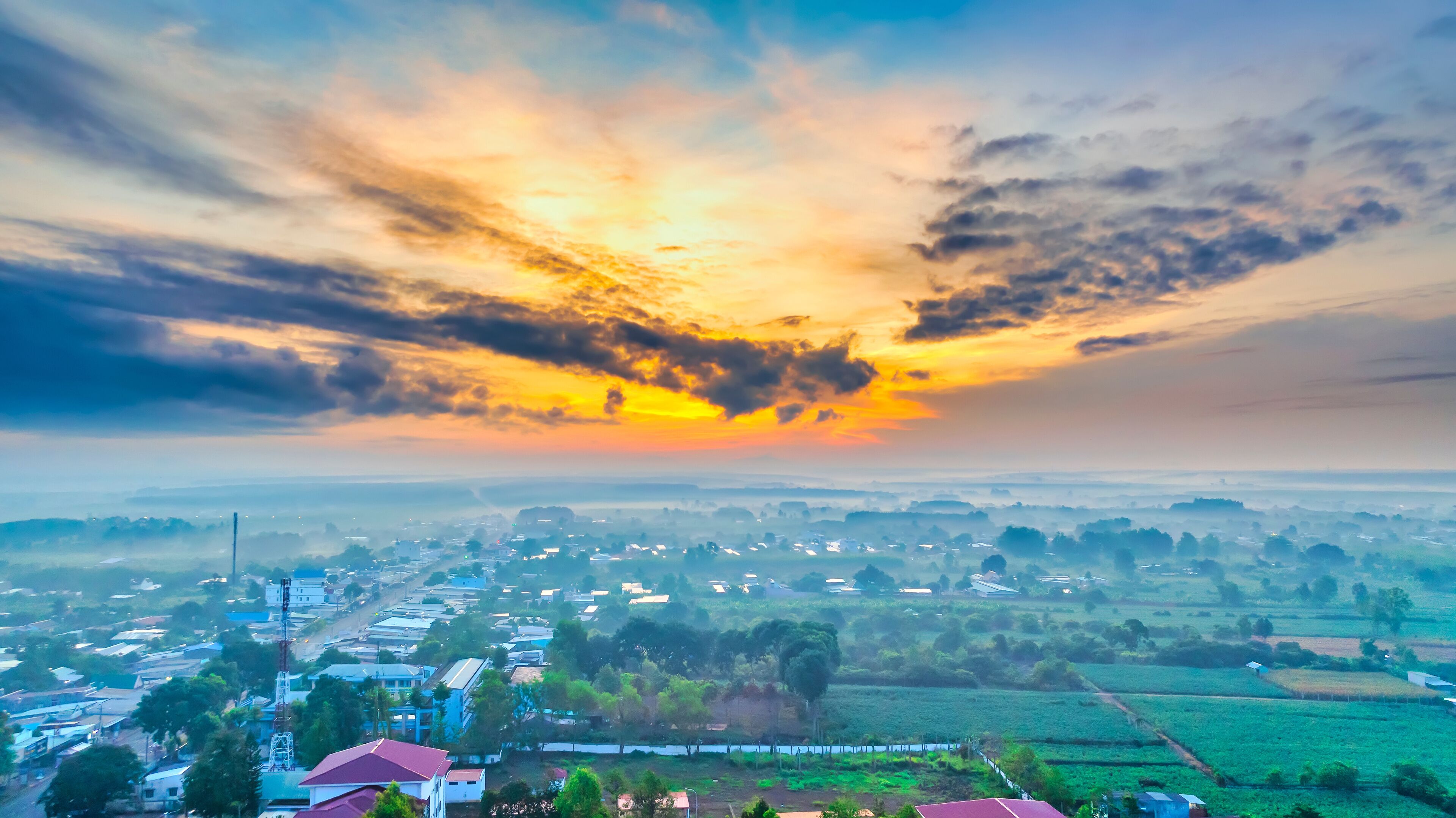 Beautiful sunrise sky above clouds with dramatic light in the suburbs near the future Long Thanh international airport. View from drone