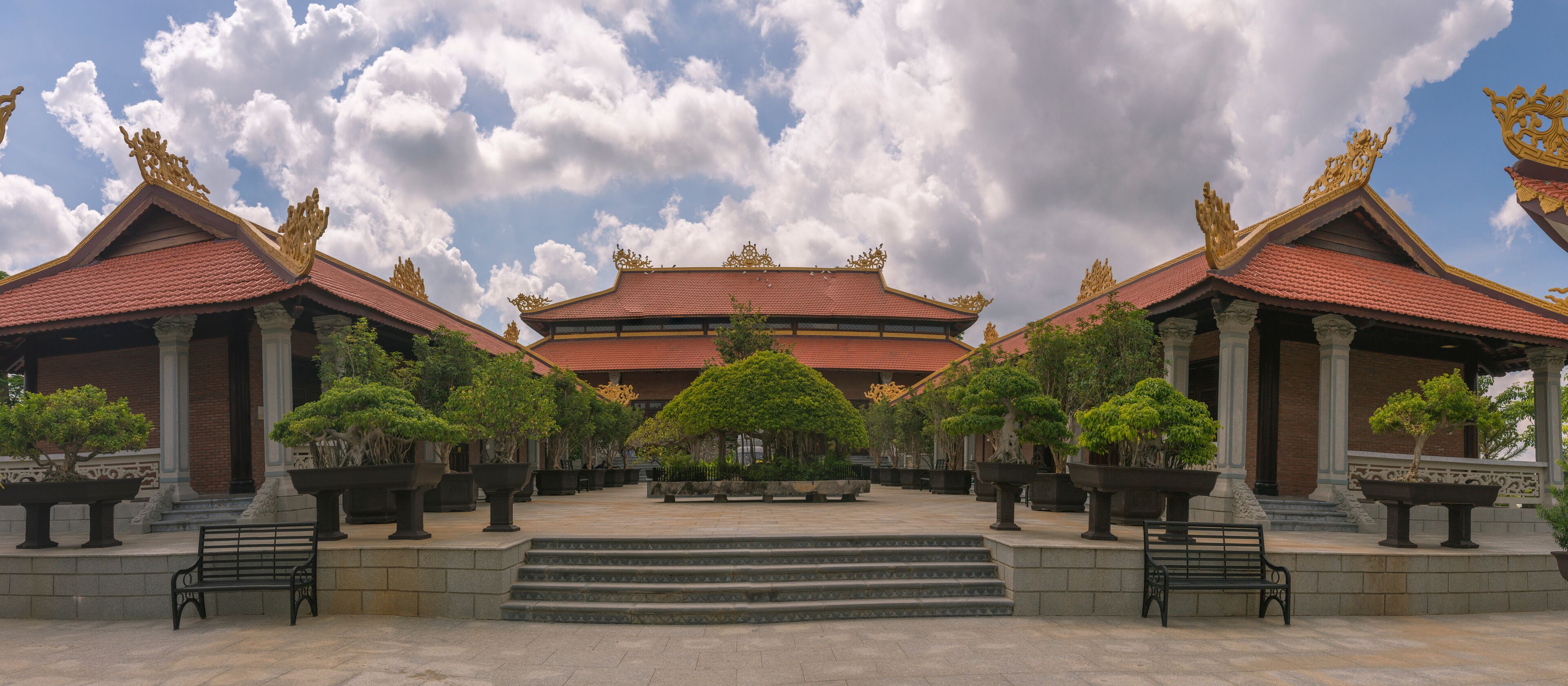 A traditional temple with ornate golden roofs and a central staircase leading to the main entrance.