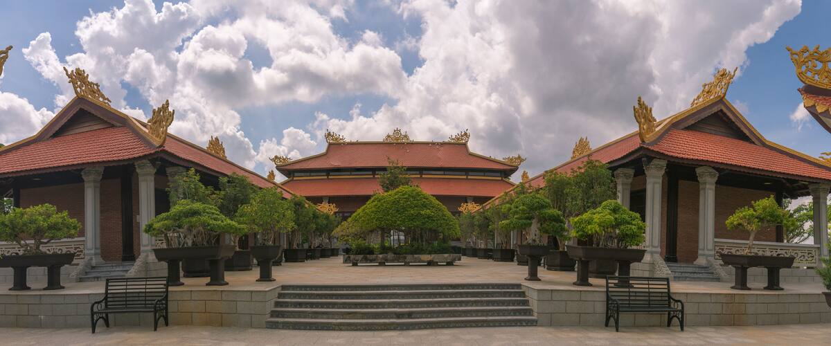 A traditional temple with ornate golden roofs and a central staircase leading to the main entrance.