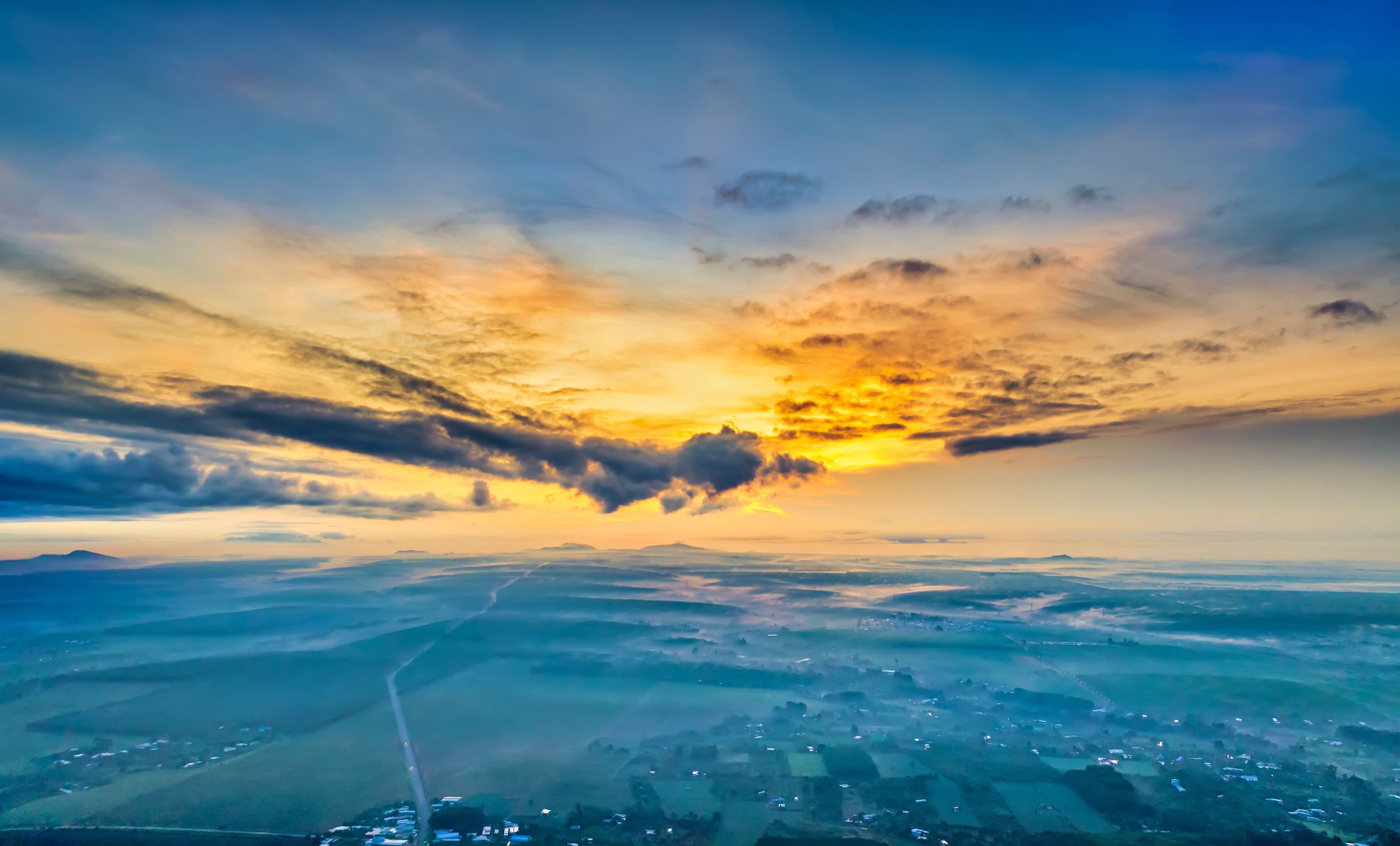 Beautiful sunrise sky above clouds with dramatic light in the suburbs near the future Long Thanh international airport. View from drone