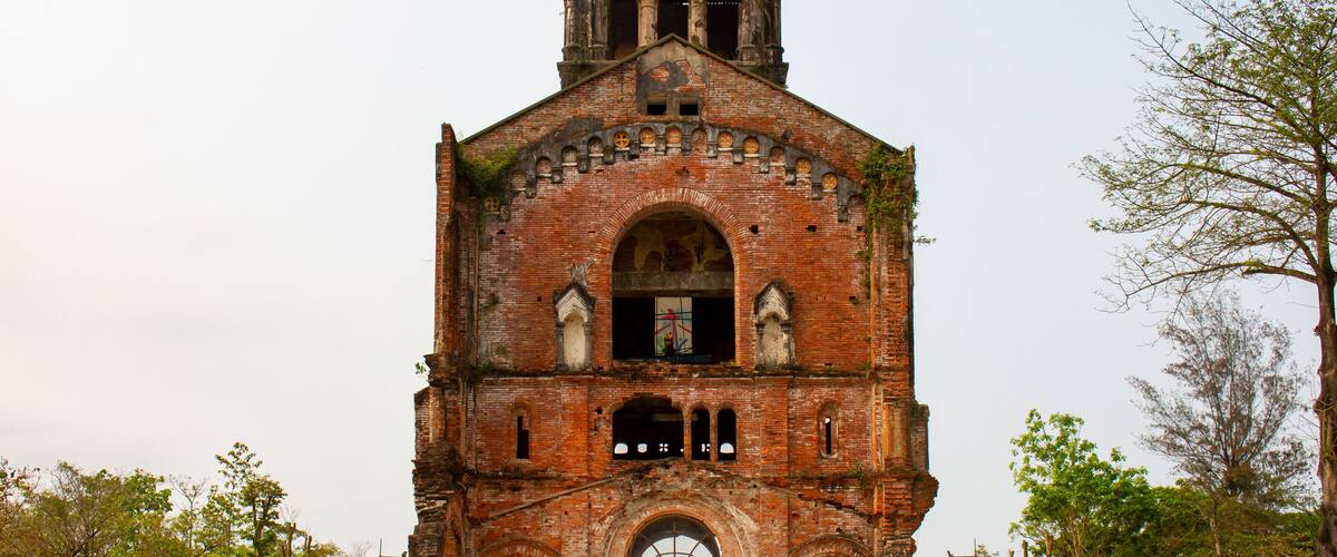 An old brick church with a bell tower and arched windows.