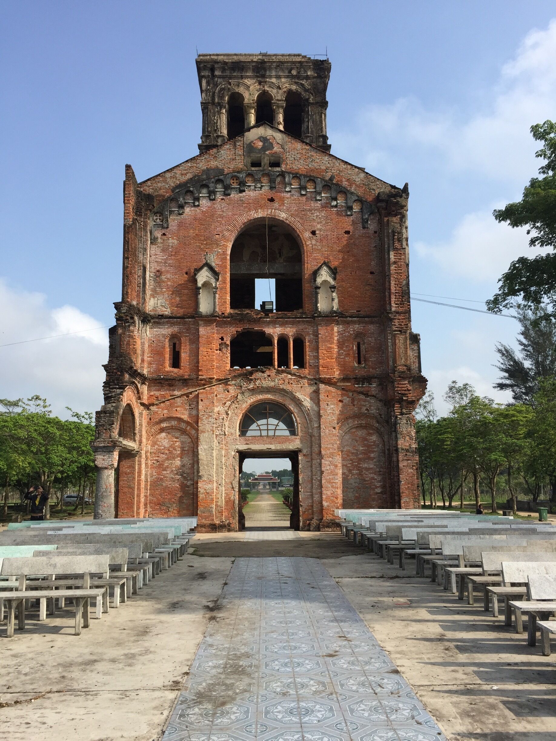 An ancient brick church with a central archway and a bell tower.