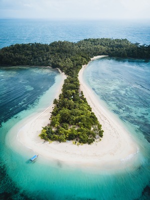 Aerial view of Cabgan Islet surrounded by turquoise water in Barobo, Surigao del Sur, Philippines