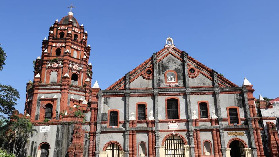 A historic church with a bell tower and a large arched entrance.