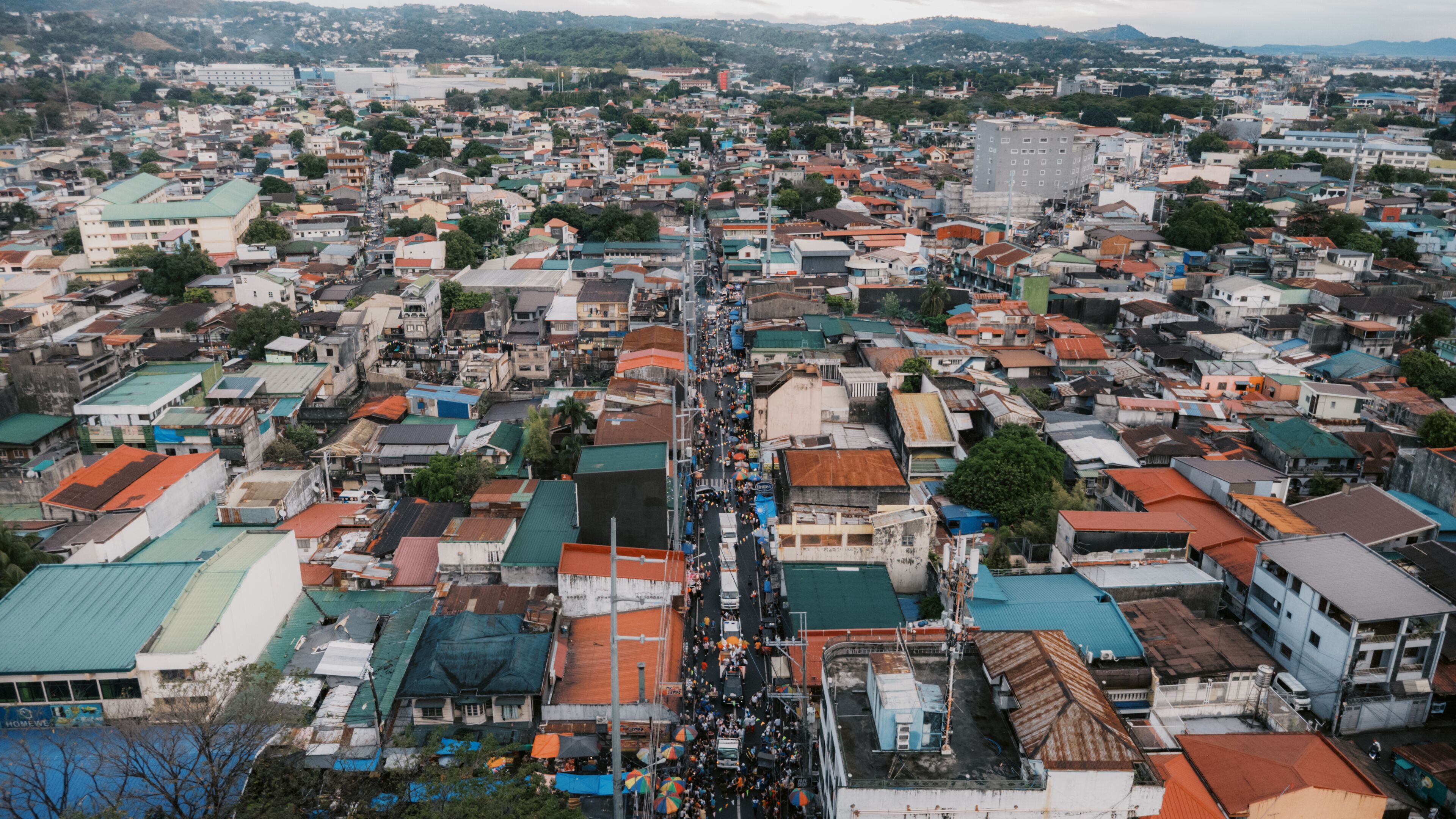 A densely packed urban area with numerous buildings and a busy street.