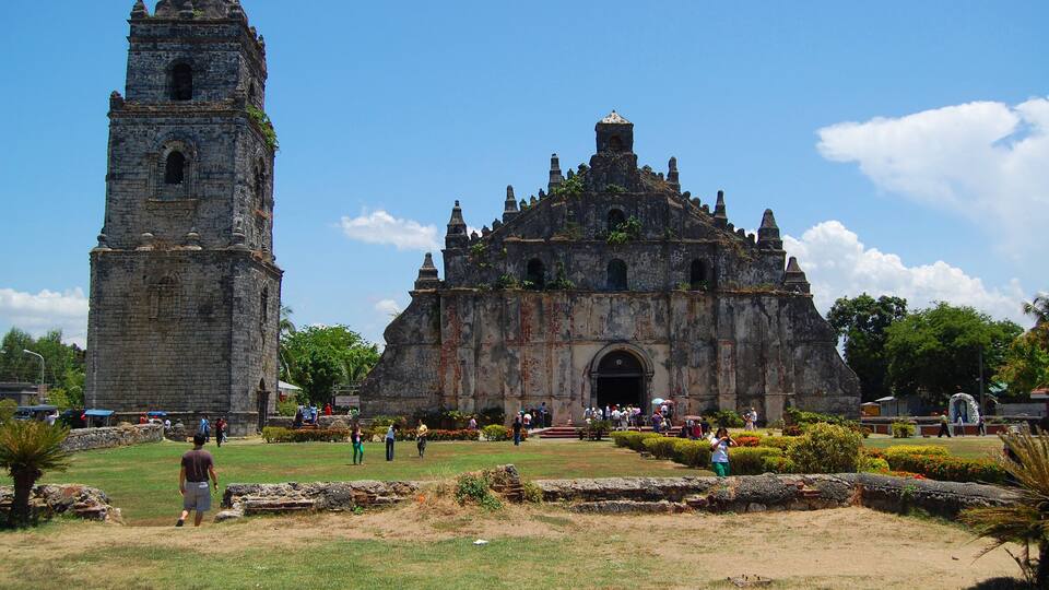 A historic stone church with a bell tower and a large entrance.