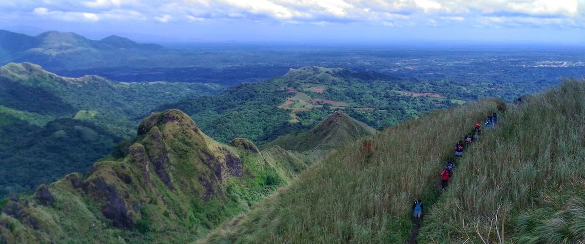 A mountainous landscape with a hiking trail and lush greenery.