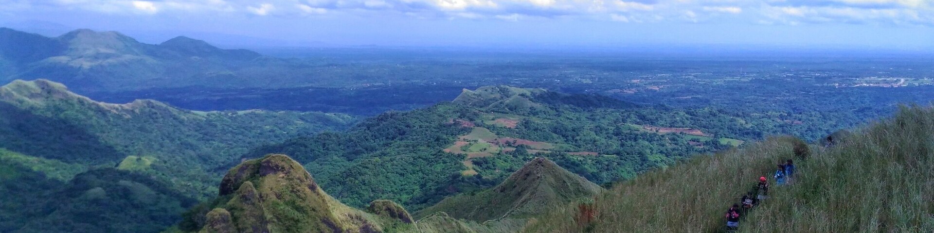 A mountainous landscape with a hiking trail and lush greenery.