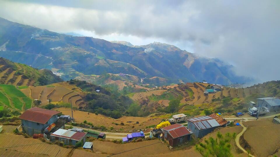 Terraced fields, small buildings, and a mountainous landscape.
